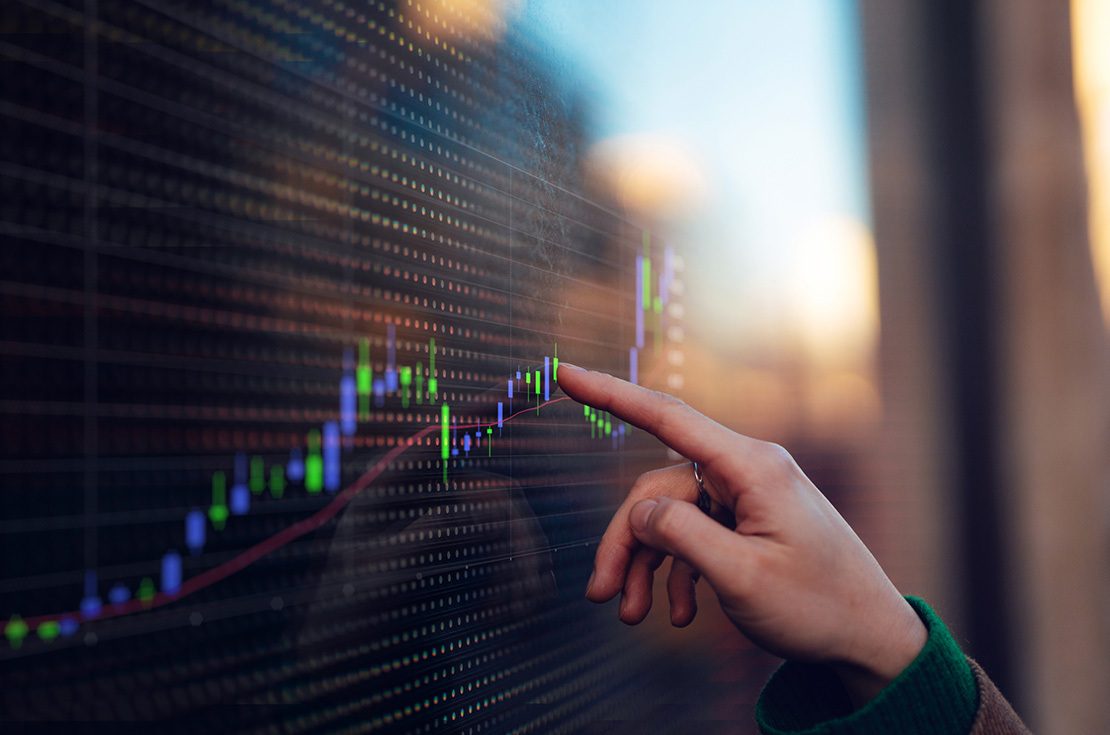 Close-up of female hand touching digital screen with financial data and charts. Financial technology. Finance and economy. Banking and investment.