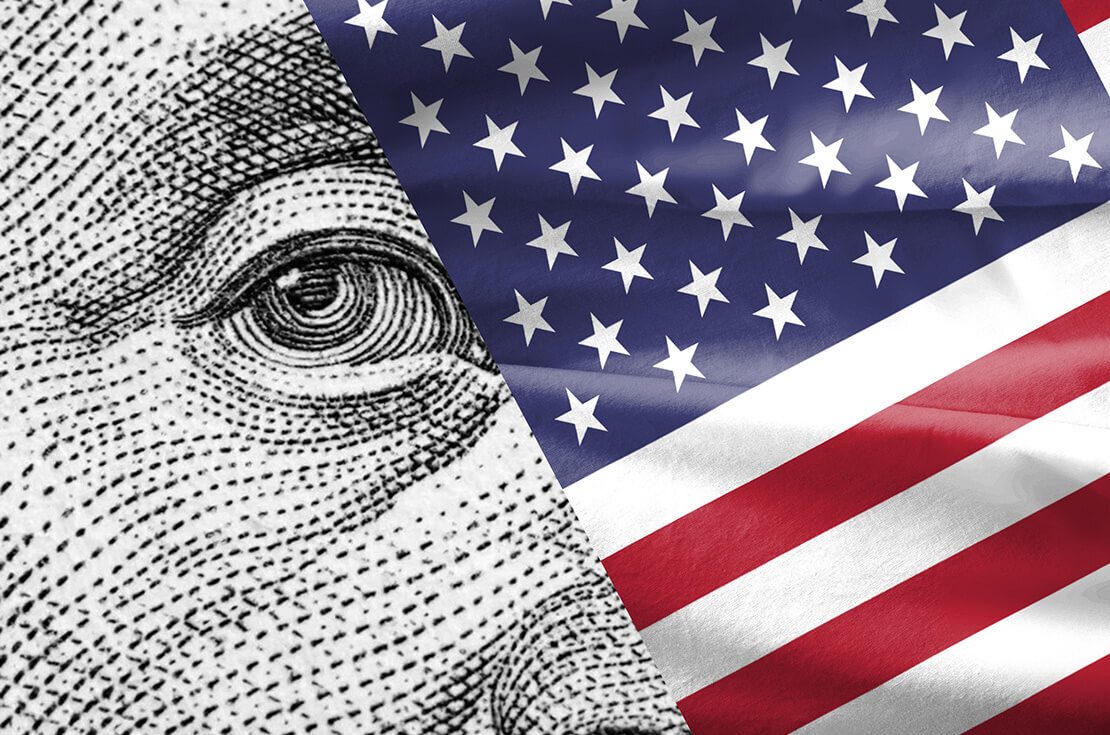 Benjamin Franklin's portrait on the one-hundred-dollar bill, peeking out from behind the U.S. flag.